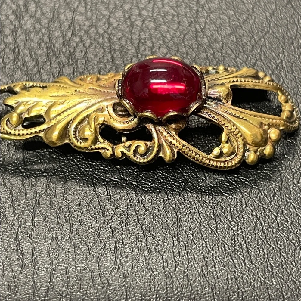 Filigree gold toned, brooch pin with red stone